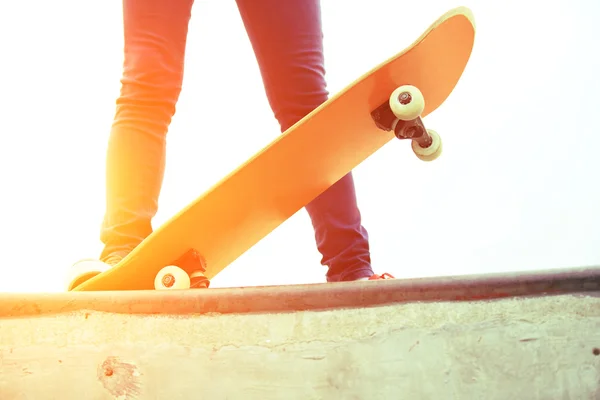 Mladá žena nohy skateboardingu skatepark rampa — Stock fotografie