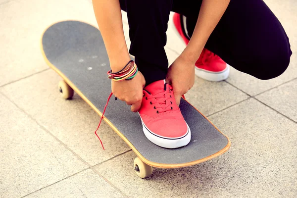 Skateboarder tying shoelace — Stock Photo, Image