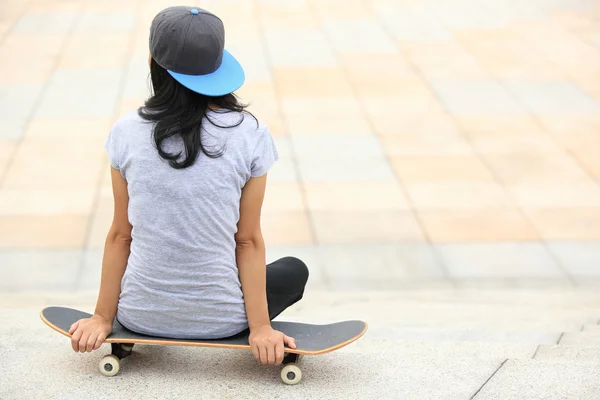 Skateboarder sit on skateboard — Stock Photo, Image