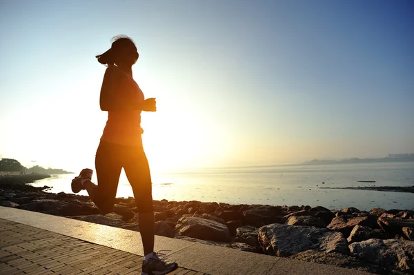 Runner athlete running on stone beach of qinghai lake — Stock Photo, Image