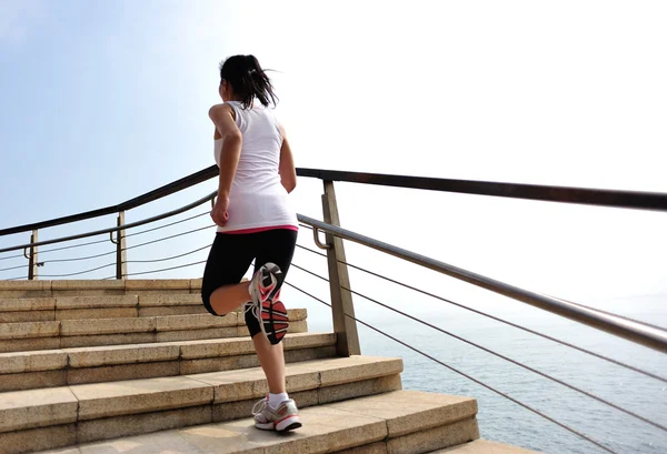 Sports woman running on stone stairs seaside — Stock Photo, Image