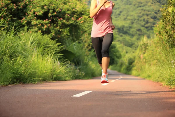 Жінка біжить лісовою стежкою — стокове фото