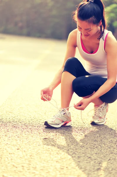 Woman runner tying shoelaces — Stock Photo, Image