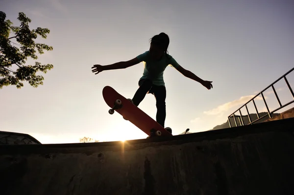 Zonsopgang vrouw skateboarden — Stockfoto