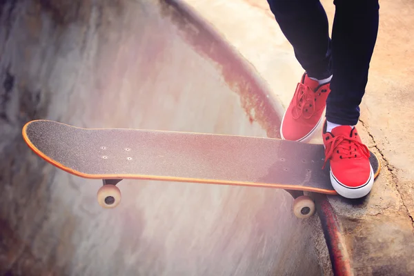Skateboarding žena nohy při východu slunce — Stock fotografie