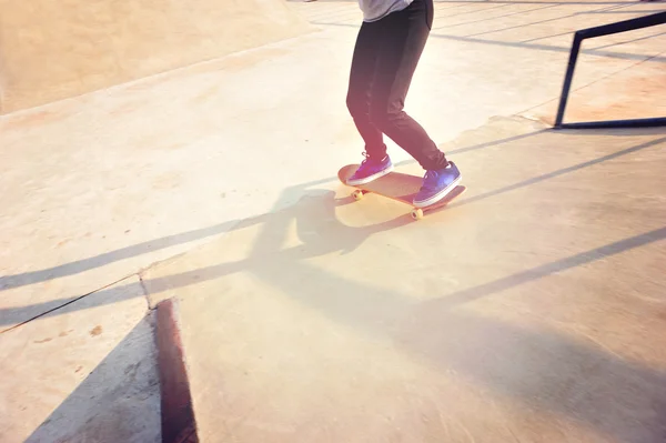 Skateboarding žena nohy při východu slunce — Stock fotografie