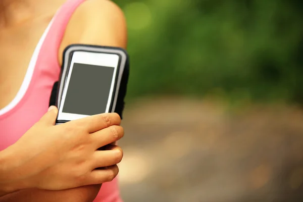 Běžec sportovec poslechu hudby z chytrý telefon mp3 přehrávač, chytrý telefon — Stock fotografie