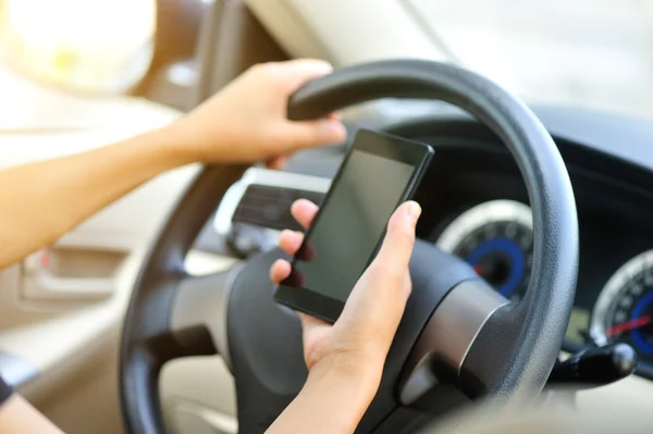 Женщина-водитель использует свой мобильный телефон — стоковое фото