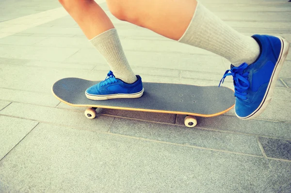 Skateboarding pernas de mulher ao nascer do sol — Fotografia de Stock