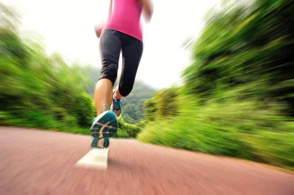 Giovane donna fitness che corre al sentiero della foresta — Foto Stock