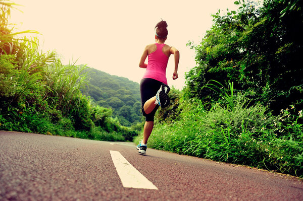 Young fitness woman  running at forest trail
