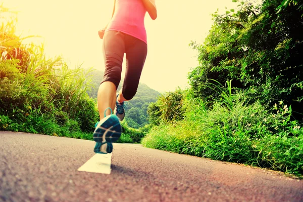 Jeune femme de remise en forme courir au sentier forestier — Photo