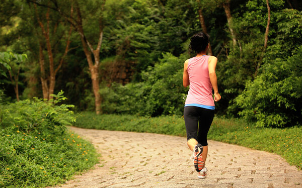 Young fitness woman  running at forest trail