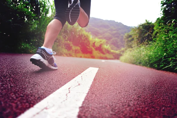 Jeune femme de remise en forme courir au sentier forestier — Photo