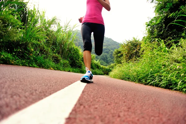 Jeune femme de remise en forme courir au sentier forestier — Photo