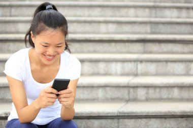 Akıllı telefon kullanan güzel genç Asyalı kadın