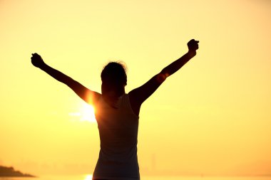 Woman open arms under the sunrise clipart