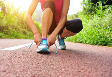 Bağcıklarını bağlayan genç bir kadın koşucu