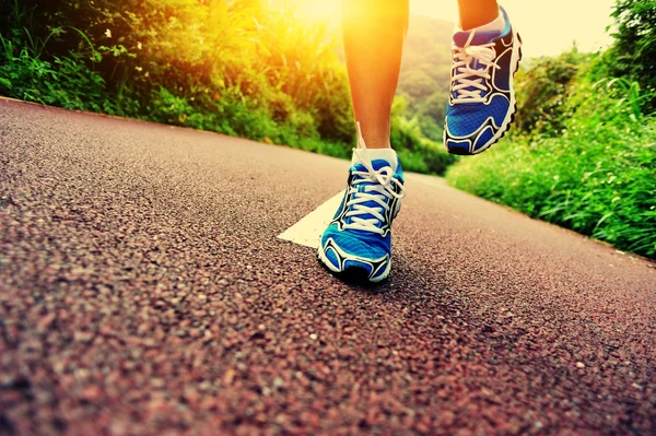 Mujer corriendo en el sendero forestal — Foto de Stock