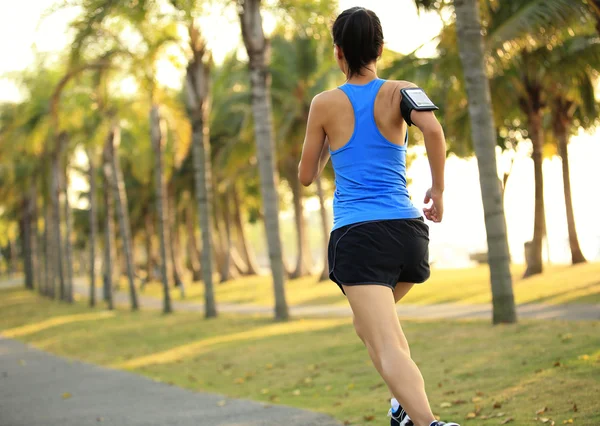 Atleta corredor correndo no parque tropical . — Fotografia de Stock