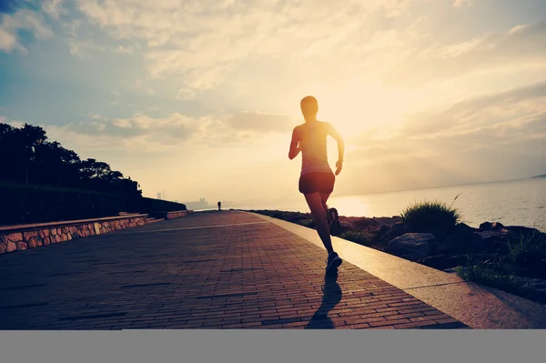 Löpare idrottsman kör på seaside. kvinna fitness silhuett sunrise jogging träning wellness koncept. — Stockfoto