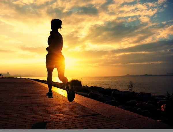 Atleta corredor corriendo a la orilla del mar. mujer fitness silueta amanecer trotar entrenamiento bienestar concepto . —  Fotos de Stock
