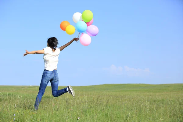 Kvinna som springer med ballonger — Stockfoto