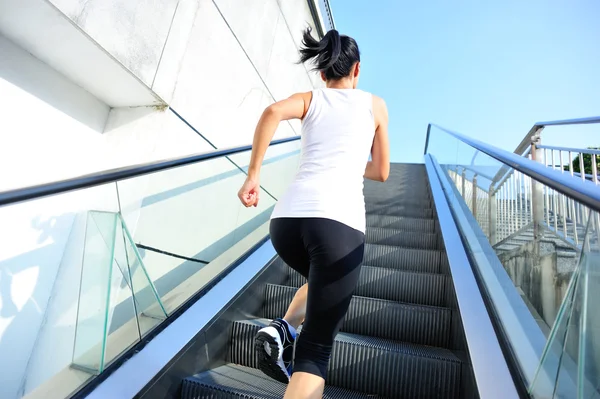 Athlete running on escalator stairs — Stock Photo, Image