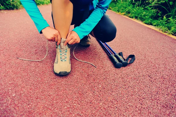 Mujer excursionista atando cordones —  Fotos de Stock