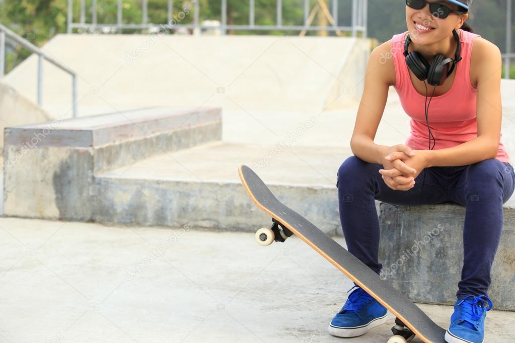 Woman skateboarder listening musi