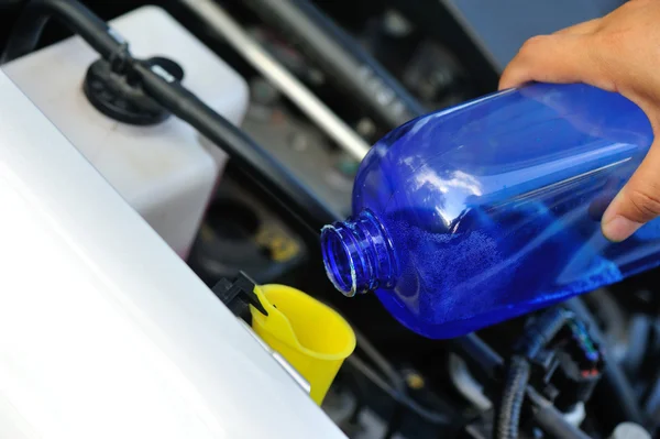 Hands adding auto glass cleaner — Stock Photo, Image