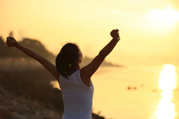 Femme bras ouverts au lever du soleil — Photo