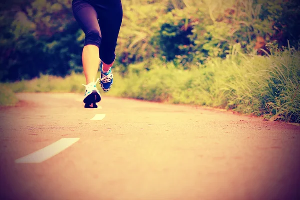 Mujer corriendo en el sendero forestal — Foto de Stock