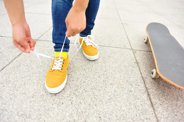 Skateboarder tying shoelace — Stock Photo, Image