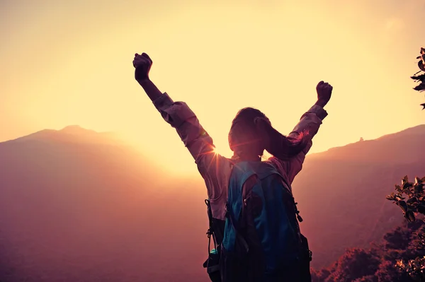 Hiker open arms at mountain peak