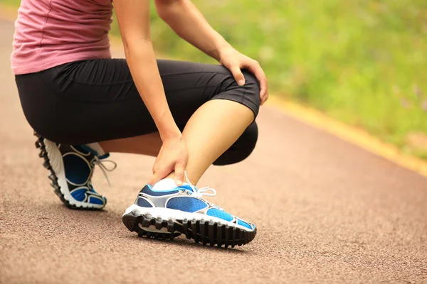 Woman runner hold her twisted ankle — Stock Photo, Image