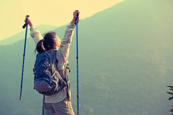 Cheering woman hiker open arms at mountain peak — Stock Photo, Image