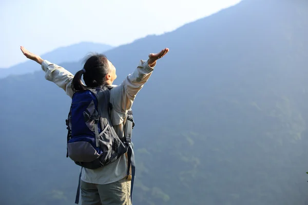 Hiker open arms at mountain peak — Stock Photo, Image