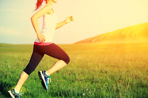 Löpare idrottsman körs på gräset vid havet. kvinna fitness soluppgång eller solnedgång jogging träning wellness koncept. — Stockfoto