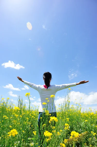 Cheering woman open arms at cole flower field — Stock Photo, Image