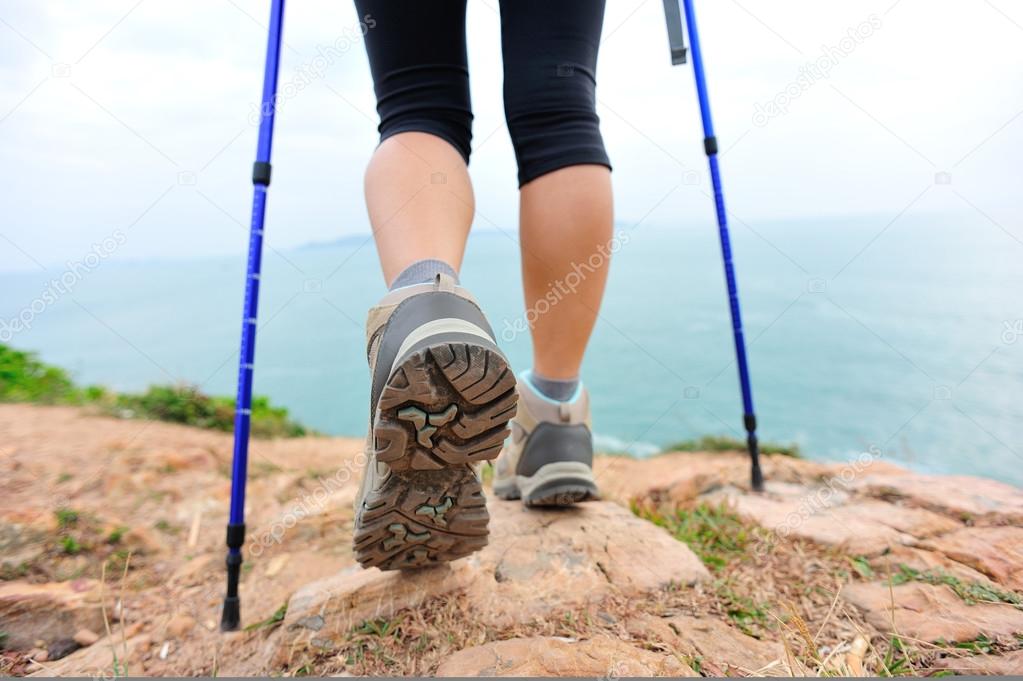 Woman hiker hiking on seaside trail