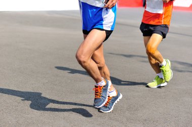 Şehir yolunda koşan maraton koşucusu bacakları