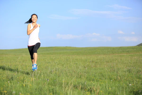 Läufer, der auf Gras am Meer läuft. Frau Fitness Jogging Workout Wellness-Konzept. — Stockfoto