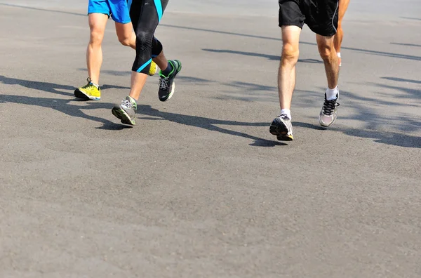 Marathon runner legs running on city road