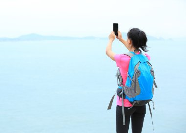 Genç kadın uzun yürüyüşe çıkan kimse kullanım akıllı telefon fotoğraf çekme