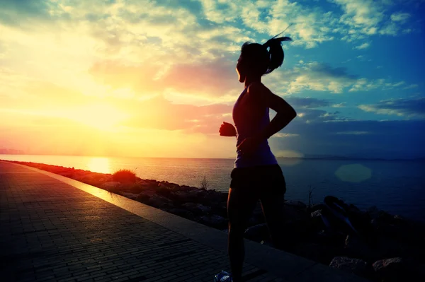 Atlet pelari lari di tepi pantai. Wanita kebugaran siluet matahari terbit jogging latihan kesehatan konsep . — Stok Foto