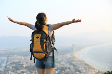 Tezahürat görünümü açık kollar ile seyir kadın stand deniz kaya hiking
