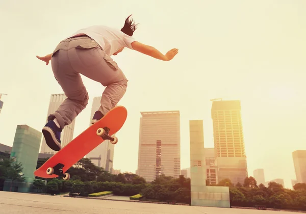 Skateboarder skateboarding při východu slunce města — Stock fotografie