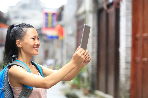 Junge asiatische Touristin hält leeres digitales Tablet — Stockfoto