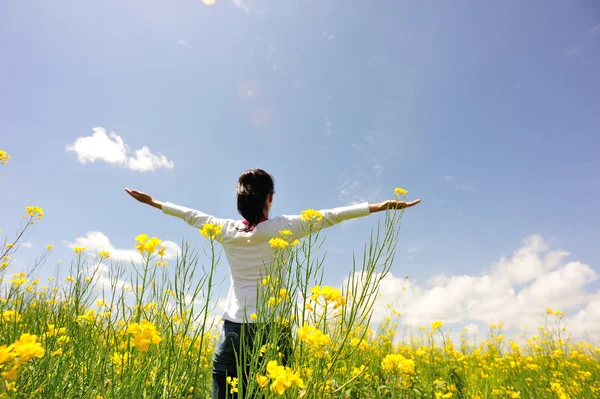 Cheering woman open arms at cole flower field — Stock Photo, Image